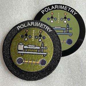 May include: Two circular patches featuring an olive green center with a black border. The text POLARIMETRY is embroidered in white at the top. The design includes a scientific instrument illustration, molecular structures, and a wave graphic.