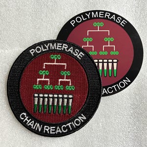 Può includere: Due toppe ricamate circolari con un centro rosso scuro e un diagramma bianco del processo di reazione a catena della polimerasi, inclusi simboli di DNA verdi e provette. Il bordo nero contiene il testo bianco POLYMERASE CHAIN REACTION.