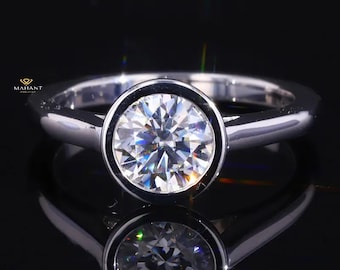 May include: A silver ring with a bezel setting featuring a large, round, clear diamond.