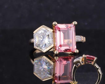 Puede incluir: Tres anillos con piedras preciosas grandes. Un anillo presenta una gema hexagonal y transparente con una banda dorada. Otro anillo tiene una gema rosa rectangular con una banda dorada. El tercer anillo tiene dos gemas, una transparente y otra rosa, con una banda dorada.