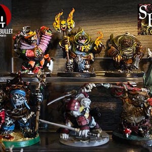 以下が含まれることがあります： それぞれがユニークなディテールとポーズを持つ、手描きされたミニチュアフィギュア7体のセットです。フィギュアは黒い背景のウッドシェルフに飾られています。フィギュアは緑、赤、青、茶色など様々な色で塗られています。フィギュアはすべてサイズと形が異なり、非常に詳細に作られています。フィギュアはすべて「Bite the Bullet」ライセンス取得のペインターコレクションの一部です。