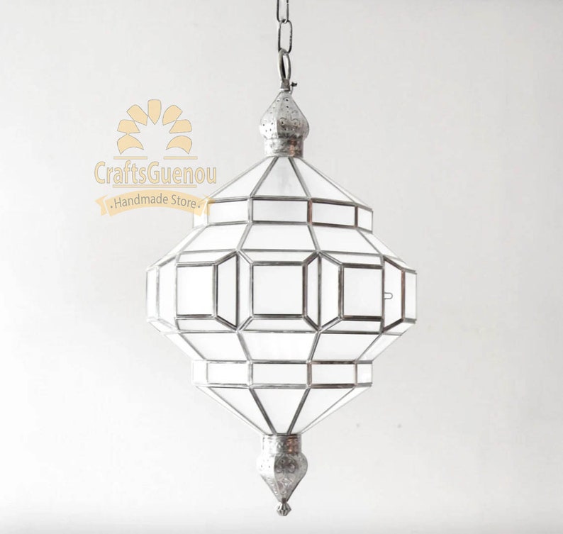 May include: A silver Moroccan pendant light with a geometric design and clear glass panels. The light is hanging from a chain.