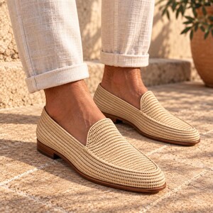 Handmade men's wedding shoes made from natural woven raffia, styled as penny loafers with a woven cross-strap detail in gray and beige tones. Unique groom footwear featuring handcrafted raffia weaving and a tan leather sole. Perfect for rustic, boho, or destination weddings. Artisan-made natural fiber loafers offering a stylish, comfortable alternative to traditional leather wedding shoes for grooms and groomsmen.