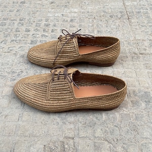 Handmade men’s raffia shoes crafted from natural woven fibers, featuring a lightweight and breathable loafer moccasin design. Ideal for weddings, beach ceremonies, summer outfits, and casual everyday wear. These artisanal raffia loafers offer a stylish, eco-friendly look with detailed handwoven texture, comfortable fit, and classic design suitable for men seeking unique, handcrafted footwear.