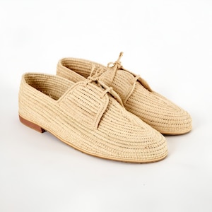 Handmade men’s raffia shoes crafted from natural woven fibers, featuring a lightweight and breathable loafer moccasin design. Ideal for weddings, beach ceremonies, summer outfits, and casual everyday wear. These artisanal raffia loafers offer a stylish, eco-friendly look with detailed handwoven texture, comfortable fit, and classic design suitable for men seeking unique, handcrafted footwear.