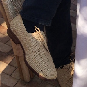 Handmade men’s raffia wedding shoes featuring natural woven fibers and a lightweight loafer design. Perfect for grooms seeking unique, stylish footwear for beach, boho, or summer ceremonies. Comfortable, breathable, and crafted with detailed handwoven texture for an elegant, natural look.