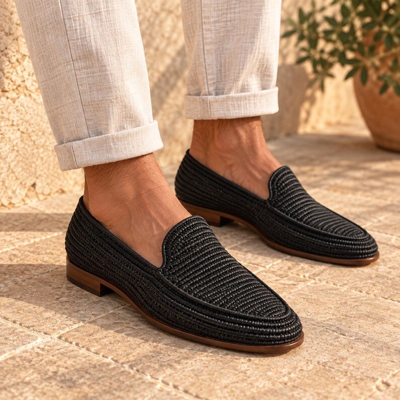 Handmade men's wedding shoes made from natural woven raffia, styled as penny loafers with a woven cross-strap detail in gray and beige tones. Unique groom footwear featuring handcrafted raffia weaving and a tan leather sole. Perfect for rustic, boho, or destination weddings. Artisan-made natural fiber loafers offering a stylish, comfortable alternative to traditional leather wedding shoes for grooms and groomsmen.