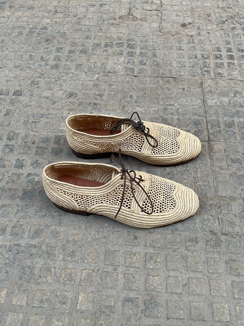 Handmade men’s raffia shoes crafted from natural woven fibers, featuring a lightweight and breathable loafer moccasin design. Ideal for weddings, beach ceremonies, summer outfits, and casual everyday wear. These artisanal raffia loafers offer a stylish, eco-friendly look with detailed handwoven texture, comfortable fit, and classic design suitable for men seeking unique, handcrafted footwear.
