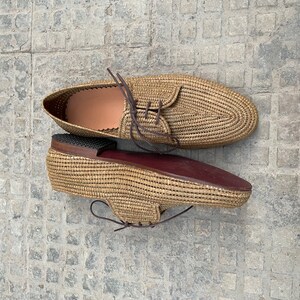 Handmade men’s raffia shoes crafted from natural woven fibers, featuring a lightweight and breathable loafer moccasin design. Ideal for weddings, beach ceremonies, summer outfits, and casual everyday wear. These artisanal raffia loafers offer a stylish, eco-friendly look with detailed handwoven texture, comfortable fit, and classic design suitable for men seeking unique, handcrafted footwear.