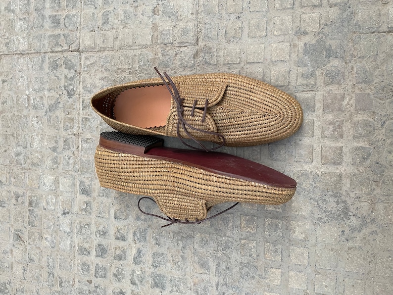 Handmade men’s raffia shoes crafted from natural woven fibers, featuring a lightweight and breathable loafer moccasin design. Ideal for weddings, beach ceremonies, summer outfits, and casual everyday wear. These artisanal raffia loafers offer a stylish, eco-friendly look with detailed handwoven texture, comfortable fit, and classic design suitable for men seeking unique, handcrafted footwear.