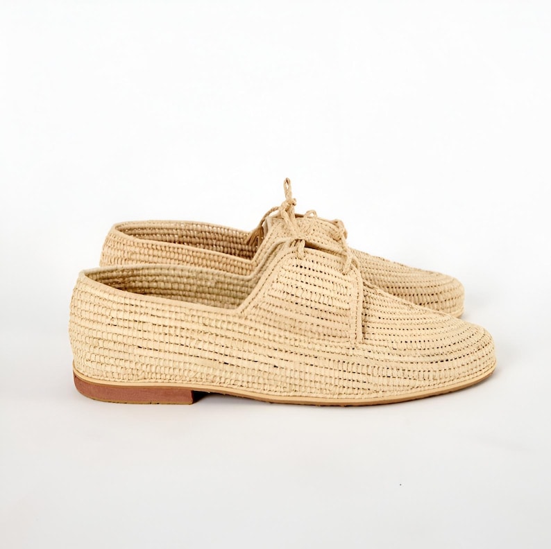 Handmade men’s raffia shoes crafted from natural woven fibers, featuring a lightweight and breathable loafer moccasin design. Ideal for weddings, beach ceremonies, summer outfits, and casual everyday wear. These artisanal raffia loafers offer a stylish, eco-friendly look with detailed handwoven texture, comfortable fit, and classic design suitable for men seeking unique, handcrafted footwear.
