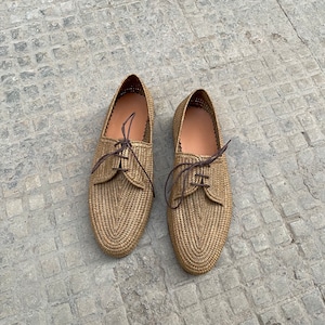 Handmade men’s raffia shoes crafted from natural woven fibers, featuring a lightweight and breathable loafer moccasin design. Ideal for weddings, beach ceremonies, summer outfits, and casual everyday wear. These artisanal raffia loafers offer a stylish, eco-friendly look with detailed handwoven texture, comfortable fit, and classic design suitable for men seeking unique, handcrafted footwear.