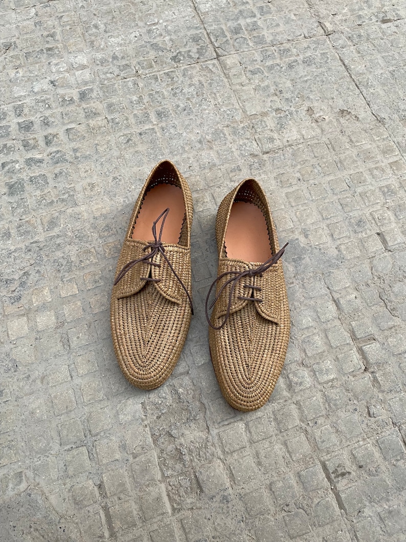 Handmade men’s raffia shoes crafted from natural woven fibers, featuring a lightweight and breathable loafer moccasin design. Ideal for weddings, beach ceremonies, summer outfits, and casual everyday wear. These artisanal raffia loafers offer a stylish, eco-friendly look with detailed handwoven texture, comfortable fit, and classic design suitable for men seeking unique, handcrafted footwear.