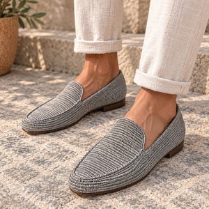 Handmade men's wedding shoes made from natural woven raffia, styled as penny loafers with a woven cross-strap detail in gray and beige tones. Unique groom footwear featuring handcrafted raffia weaving and a tan leather sole. Perfect for rustic, boho, or destination weddings. Artisan-made natural fiber loafers offering a stylish, comfortable alternative to traditional leather wedding shoes for grooms and groomsmen.