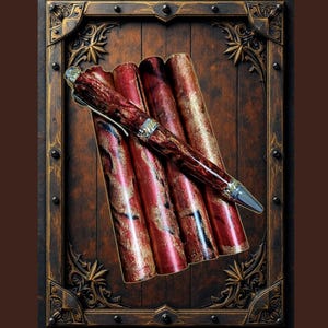 May include: A set of four red and gold pens with a marbled design. The pens are displayed in a wooden frame with ornate carvings.