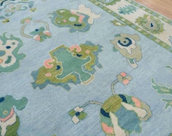 Light blue and cream with green accent oushak rug for living room and home decor.