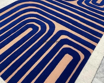 Loop-cut with high-low pattern hand tufted rug in beige background and blue design for living room and home decor.