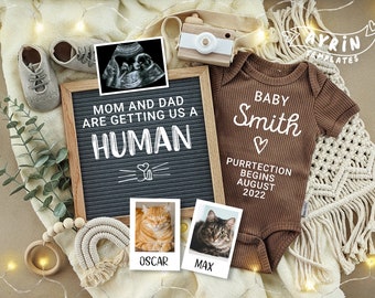 May include: A brown onesie with the text "BABY Smith PURRTECTION BEGINS AUGUST 2022" on it. A letter board with the text "MOM AND DAD ARE GETTING US A HUMAN" is next to the onesie. There are two ultrasound images, a wooden camera, and two pictures of cats.