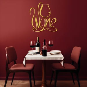 May include: A dining scene with a red wall and a small table set for two. The table has a white tablecloth, two wine glasses, and two bottles of wine. A gold-colored "Wine" sign is on the wall.