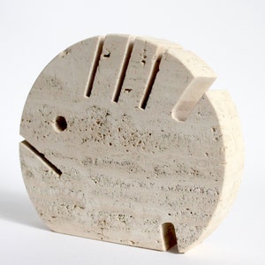 K&ouml;nnte beinhalten: Eine wei&szlig;e Steinskulptur eines Fisches mit einem Loch an der Seite. Die Skulptur ist detailliert geschnitzt und hat eine raue Textur.