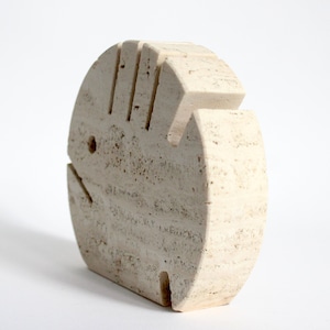 K&ouml;nnte beinhalten: Eine wei&szlig;e Steinskulptur einer stilisierten Hand, in einer kreisf&ouml;rmigen Form geschnitzt. Die Skulptur hat eine raue, strukturierte Oberfl&auml;che und ist aus Travertin.