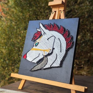 May include: A white ceramic mug with a black handle and the text "But First, Coffee" in a bold, black font. The mug is set against a blurred background, suggesting a cozy setting.