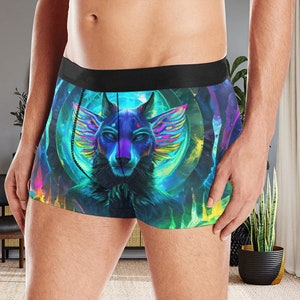 Puede incluir: Calzoncillos tipo bóxer con un estampado gráfico vibrante y multicolor de un lobo estilizado con grandes orejas emplumadas. El diseño incorpora tonos azulados, púrpuras y verde neón con un elemento de fondo circular y una cinturilla negra sólida.