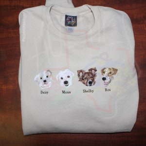 Puede incluir: Una sudadera beige con im&aacute;genes bordadas de cuatro perros. Los perros se llaman Daisy, Maxx, Shelby y Rex.