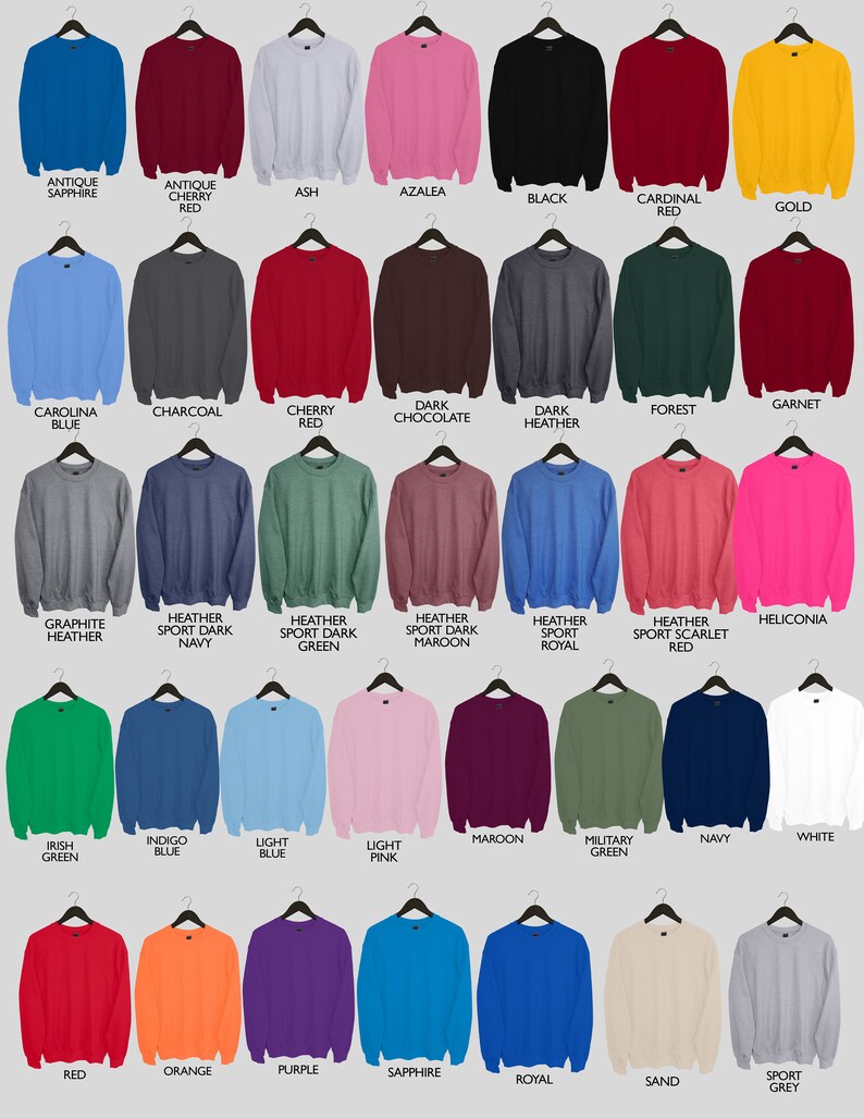 May include: A collection of 25 different colored crew neck sweatshirts, each with a hanger. The sweatshirts are arranged in five rows of five, with each row representing a different color family. The colors include antique sapphire, antique cherry red, ash, azalea, black, cardinal red, gold, carolina blue, charcoal, cherry red, dark chocolate, dark heather, forest, garnet, graphite heather, heather sport dark navy, heather sport dark green, heather sport dark maroon, heather sport royal, heather sport scarlet red, heliconia, irish green, indigo blue, light blue, light pink, maroon, military green, navy, white, red, orange, purple, sapphire, royal, sand, and sport grey.