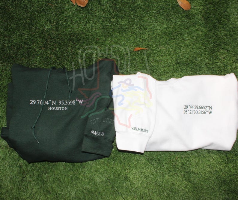 May include: Two sweatshirts with different designs. The green sweatshirt has the text "29.7604 N 95.3698 W HOUSTON EST 205 MMXV" printed on it. The white sweatshirt has the text "29&deg;44'59.6652"N 95*21'30.3156"W VILLMMXVI" printed on it.