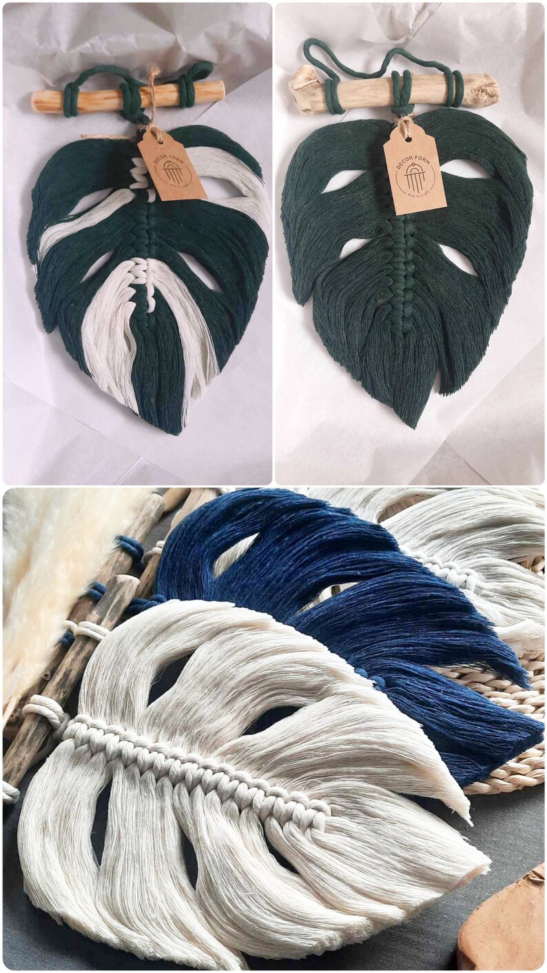 May include: Three macrame wall hangings in the shape of monstera leaves. The leaves are made with white, dark green, and navy blue cotton cord. The leaves are hanging from a wooden dowel rod.