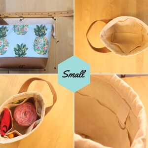 May include: A small, light blue canvas tote bag with a pineapple print and brown leather trim. The bag measures 10 inches wide, 7 inches tall, and 3.5 inches deep. The bag has a brown leather handle and a drawstring closure. The bag is shown with a yarn ball and other small items inside.