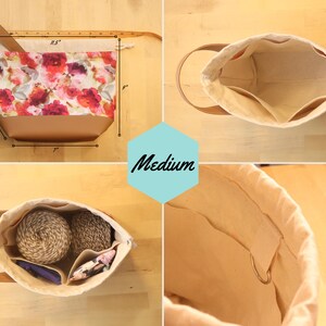 May include: A medium-sized beige canvas bag with brown leather handles. The bag has a drawstring closure and is lined with a floral fabric. The bag is 11.5 inches wide, 9 inches tall, and 7 inches deep. The bag is shown with yarn and other supplies inside.