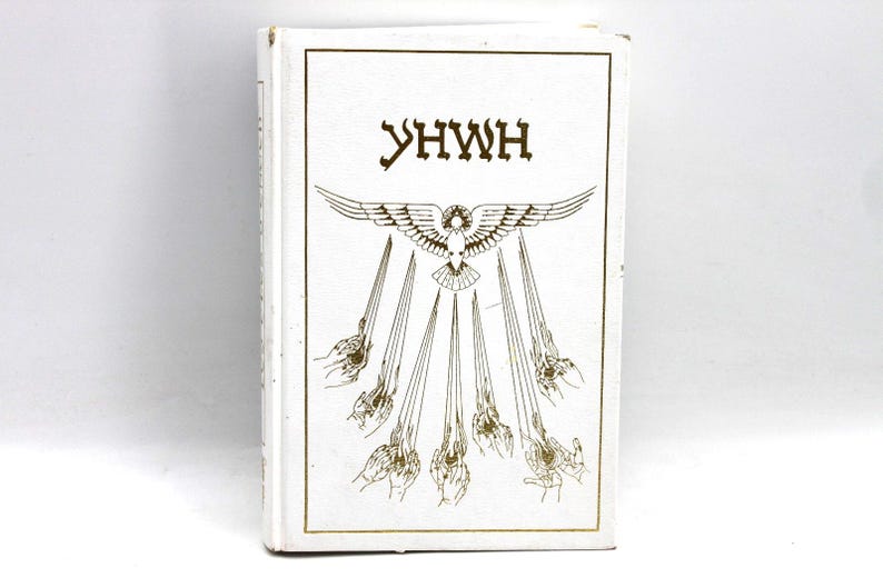 May include: A white book with gold lettering and illustrations. The cover features the word "YHWH" above a design of a bird with outstretched wings, from which rays emanate, ending in hands.