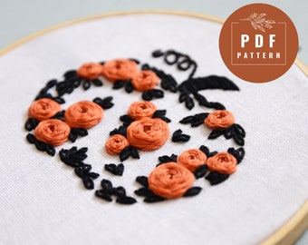May include: Embroidered pumpkin design with orange roses and black leaves. The design is on a white fabric background. The image includes the text "PDF PATTERN".