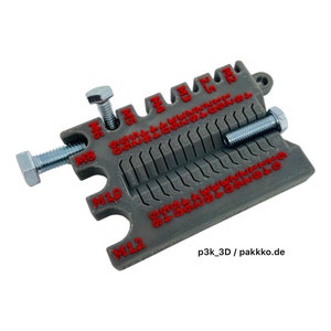 Peut inclure: Un outil en plastique gris pour mesurer la taille des boulons et des écrous. L'outil est gradué pour les tailles M6, M8, M10 et M12. L'outil est marqué "p3k_3D / pakkko.de".