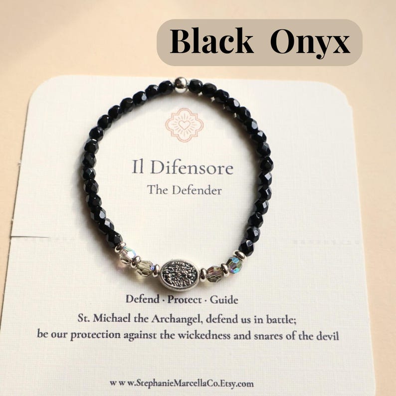 May include: Black Onyx bracelet with faceted black beads, clear and iridescent accent beads, and a silver-toned centerpiece. The card behind the bracelet reads "Il Difensore, The Defender."