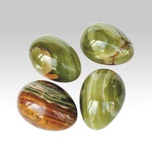 May include: Four polished, oval-shaped stones in shades of green, brown, and white. The stones have a glossy finish, with visible natural patterns and variations in color. The arrangement suggests a decorative or collectible item.
