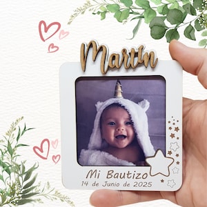 Può includere: Una cornice bianca con il nome "Martin" in lettere di legno. La cornice contiene una foto di un bambino che indossa un asciugamano con cappuccio a tema unicorno. Il testo "Mi Bautizo 14 de Junio de 2025" è stampato in basso.