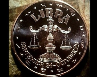 Peut inclure: Une pièce de monnaie de couleur cuivre avec un symbole du zodiaque de la Balance en argent, des balances et les dates du 24 septembre au 23 octobre.