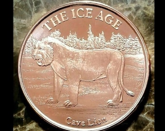 Peut inclure: Une pièce de monnaie de couleur cuivre représentant un lion des cavernes et le texte "THE ICE AGE Cave Lion".