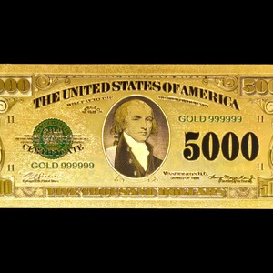 May include: A gold-coloured $5000 bill with the text "THE UNITED STATES OF AMERICA" and a portrait of a man. The bill also features the text "GOLD 999999" and the number "5000" in large print.