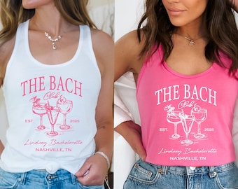 May include: White and pink tank tops with the text "THE BACH Club" and "Lindsey Bachelorette Nashville, TN" printed on the front. The design includes illustrations of cocktails and the year 2026 or 2025.