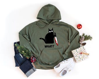 May include: A green hooded sweatshirt with a black cat holding a bloody knife and the text "WHAT?" printed on the front.
