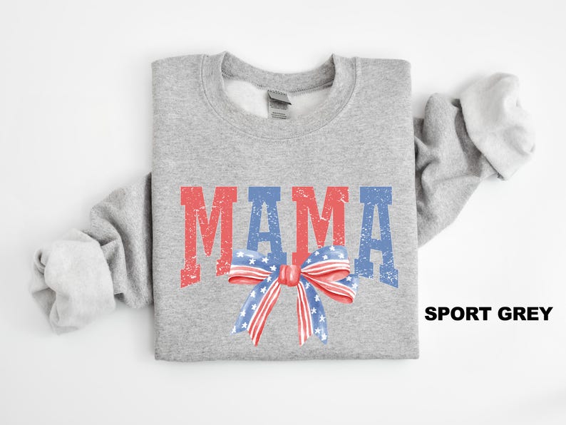 Pu&ograve; includere: Una felpa grigia con la parola "MAMA" in lettere rosse e blu con un fiocco rosso, bianco e blu. La felpa &egrave; disponibile in grigio sportivo.