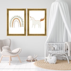 May include: Two framed prints, one with a rainbow and greenery, the other with a white unicorn. The prints are hanging on a white wall in a nursery setting.