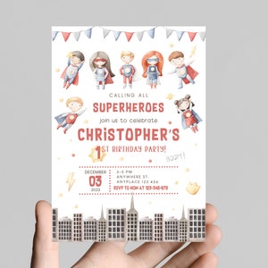 Puede incluir: Una invitación a una fiesta de primer cumpleaños con temática de superhéroes con una ilustración de acuarela de seis superhéroes volando en el cielo. La invitación presenta el texto "Calling all Superheroes" y "Christopher's 1st Birthday Party!" con un esquema de color rojo y blanco. La invitación también incluye la fecha, la hora y la ubicación de la fiesta.