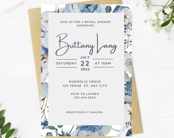 May include: A blue and white floral bridal shower invitation with the text "Join us for a bridal shower honoring Brittany Lang, Saturday, July 22, 2022 at 10 AM, Magnolia Venue, 123 Venue St. Any City, RSVP to Lauren, 333.444.5555, Registered at Amazon."
