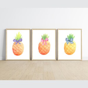 May include: Three watercolor paintings of pineapples with different colored bows. The pineapples are yellow and orange with green tops. The bows are purple, pink, and blue.