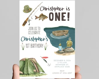 May include: A blue and green illustrated invitation for a first birthday party with a fishing theme. The invitation features a fishing rod, a fish, a boat, a tent, and two people fishing. The text on the invitation reads "Christopher is ONE!" and "Join us to celebrate Christopher's 1st Birthday".